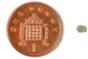 construction dust - size comparison of one penny against a grain of salt
